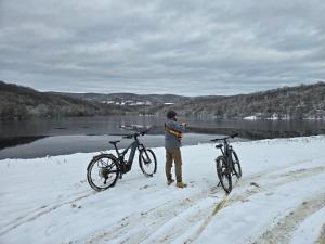 a man standing next to two bikes in the snow at Arashenda nest in Arashenda