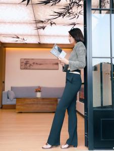 a woman standing in a room holding a book at NAIYI Forest Park Resort in Zhangjiajie