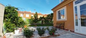a backyard of a house with a bench and plants at El Encanto de Valladolid in Aldeamayor de San Martín