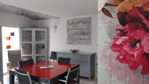 a dining room with a red table and chairs at El Encanto de Valladolid in Aldeamayor de San Martín