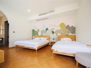 two beds in a room with a mural on the wall at LeD Courtyard Homest ay乐东小院民宿 in Beijing