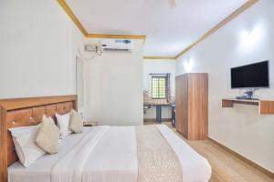 a bedroom with a bed with a tv on the wall at Hotel Calangute bay in Calangute