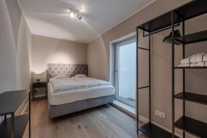 a bedroom with a bed and a window at Pure Tinnum in Sylt