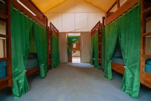 an inside view of a tent with green curtains at Pemimpi Sumba in Lambatama