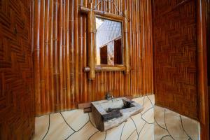 a wooden bathroom with a sink and a window at Pemimpi Sumba in Lambatama +65 photos