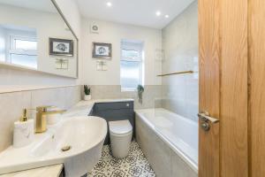 a bathroom with a sink and a tub and a toilet at WJShortlets - 48HarwellRd in Abingdon