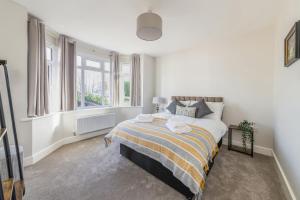 a bedroom with a bed in a room with windows at WJShortlets - 48HarwellRd in Abingdon +3 photos