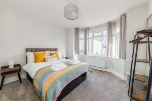 a bedroom with a bed with a colorful blanket at WJShortlets - 48HarwellRd in Abingdon