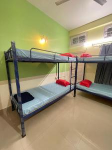 a room with three bunk beds in a room at Patkai Backpackers Hostel in Guwahati