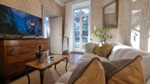 a living room with a couch and a tv at Maison Barbaira in Barbaira