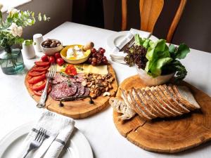 a table with two wooden cutting boards with meat and vegetables at Namibgrens Guest Farm in Namibgrens