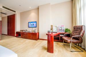 ein Hotelzimmer mit Schreibtisch und Stuhl in der Unterkunft Minghua Hotel in Wen-su-lao-ch'eng
