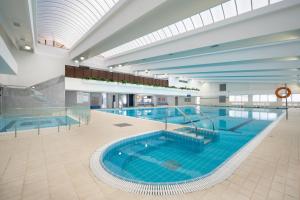 ein großes Schwimmbad in einem großen Gebäude in der Unterkunft Palm Beach Hotel - Mehadrin Kosher suitable for Ultra-Orthodox guests in Akkon