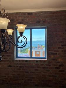 a window with a view of the ocean at Casa Balena - The Seafront Whale House Experience in Gansbaai +38 photos