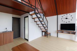 a staircase in a living room with a clock on the wall at Dieng Ceria Resort in Diyeng +42 photos