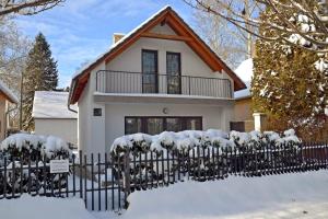a house with a fence covered in snow at Fanni Vendégház in Dombóvár