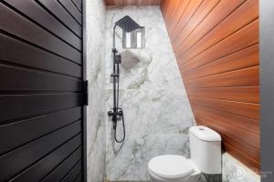 a bathroom with a shower with a toilet in it at Dieng Ceria Resort in Diyeng
