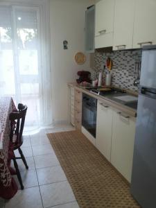 a kitchen with white cabinets and a stove top oven at B&b Irma in Olivarella