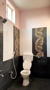 a bathroom with a toilet with a phone on the wall at Dreamy serenity beach side in Pondicherry +76 photos