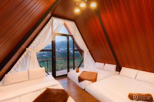 two white couches in a room with a large window at Dieng Ceria Resort in Diyeng