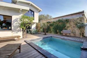 a swimming pool on a deck next to a house at Maison d'architecte 4 chambres avec piscine in Anglet