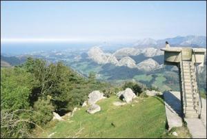 a person standing on top of a hill with mountains at Apartamentos El Castañeu in Corao