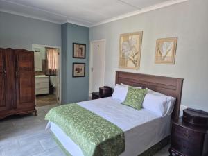 a bedroom with a bed with a green blanket on it at Malibu Waters in Port Edward