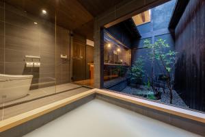 a bathroom with a bath tub and a window at Guesthouse Hana - Harmony Villa in Kyoto