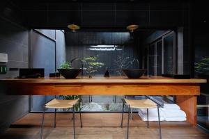 a kitchen with a counter with two sinks and stools at Guesthouse Hana - Harmony Villa in Kyoto +30 photos