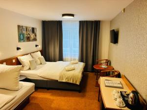 a hotel room with two beds and a table at Hotel Sněžka in Špindlerův Mlýn