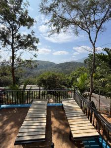 a deck with benches and a view of the mountains at Bliss Lodge Diyaluma in Demodara
