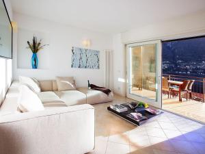 een woonkamer met een witte bank en een tafel bij Laglio Apartment in Laglio
