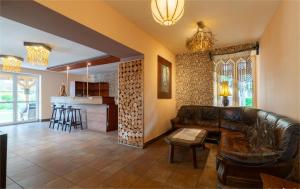 a living room with a leather couch and a kitchen at Noclegi Michaś in Krasnobród
