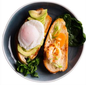 a sandwich with an egg and avocado on a plate at Artsy Minimalist Suite in Southend-on-Sea