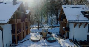 an apartment building with a courtyard in the snow at Rezydencja Aqua SPA & Wellness by GRANO in Szklarska Poręba