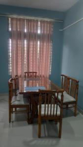 a dining room table with two chairs and a table and a window at The Siiying in Pāsighāt