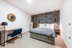 a bedroom with a bed and a desk and a chair at Thea Villas in Makry Gialos +72 photos