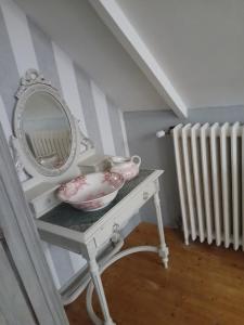 a dressing table with a mirror and bowls on it at au calme a 2pas des côtes du finistere sud in Bannalec