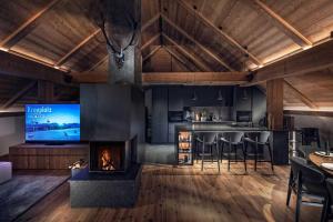 a living room with a fireplace and a bar with stools at Sorafurcia Lodge in Sorafurcia