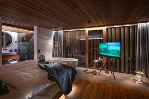 a bedroom with a bed and a flat screen tv at Sorafurcia Lodge in Sorafurcia +17 photos