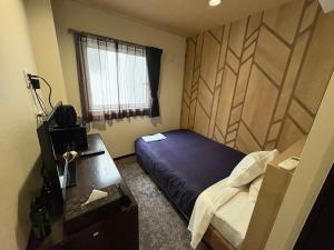 a bedroom with a bed and a desk and a window at HOTEL LiVEMAX Himeji Ekimae in Himeji