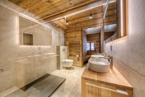 a bathroom with two toilets and a sink and a shower at Central High-End Duplexes, Sauna and Stove in Champéry