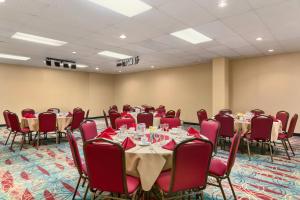 a conference room with tables and chairs with red napkins at Days Inn by Wyndham Stephenville in Stephenville