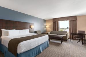 a hotel room with a bed and a desk at Days Inn by Wyndham Stephenville in Stephenville