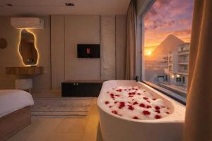 a bath tub in a room with a window at Pyramids Height Luxury Wing in Cairo