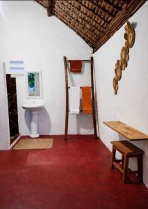 a bathroom with a toilet and a wooden table at MBOTY Village in Vohemar
