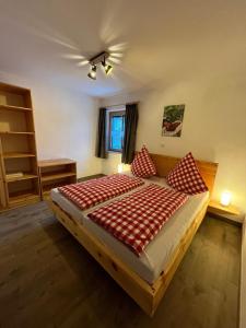 a bedroom with a large bed with red and white pillows at Woidzeit by Sigl in Kollnburg