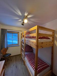 two bunk beds in a small room with a window at Woidzeit by Sigl in Kollnburg