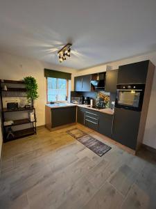 a large kitchen with black cabinets and a counter at Woidzeit by Sigl in Kollnburg