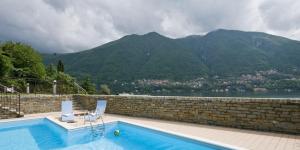 a swimming pool with a view of a mountain at Laglio Apartment in Laglio